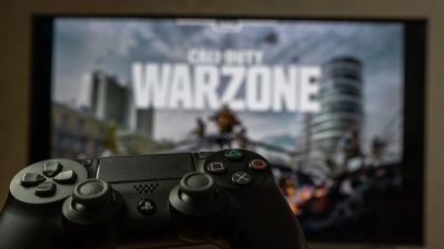En playstationkontroll i förgrunden, i bakgrunden syns Call of Duty på tv:n.