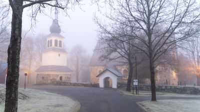 En vacker medeltida kyrka en dimmig vintermorgon.