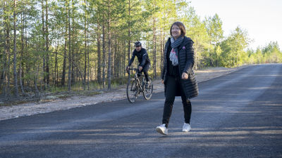 En person går och en annan cyklar på cykelvägen.