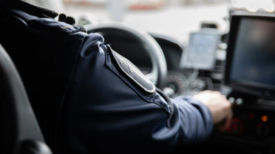 En polis kör en polisbil.