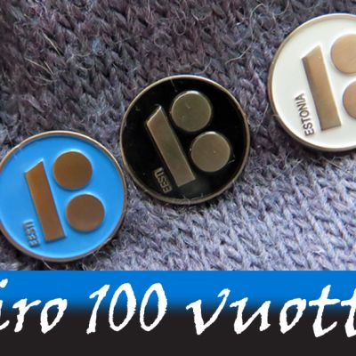 Sininen, musta ja valkea rintamerkki, joissa yhdistyvät numerot 100 ja 18.