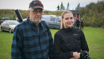 En man i rutig skjorta och en kvinna i svart jacka ler mot kameran.