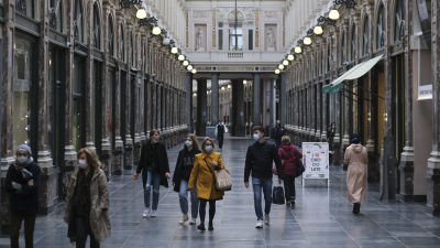 Bild på personer med ansiktsskydd som går inne i shoppingscenter i Bryssel.