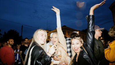 Tre kvinnor firar fotbollsherrarnas vinst. De posterar med händerna i luften.
