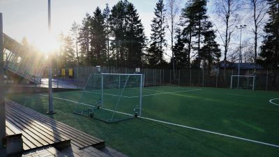 Inhägnad fotbollsplan på en skolgård.