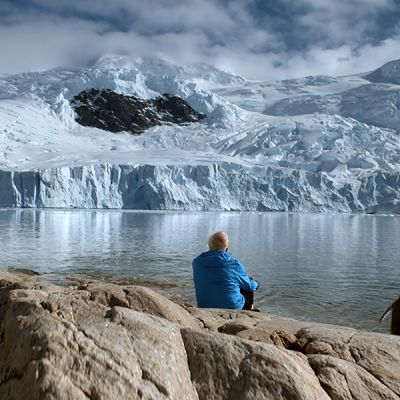 Jäätikkötutkija Claude Lorius ja pingviini Antarktiksella.