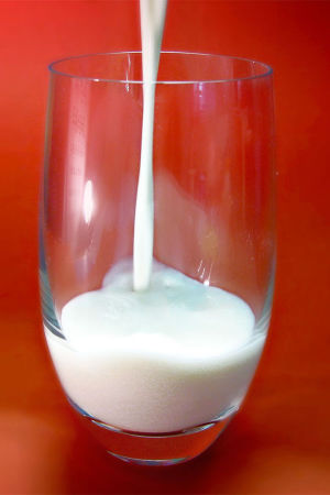 Maitoa kaadetaan lasiin.