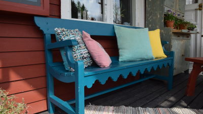 Turkos bänk med ryggstöd på Strömsös veranda.