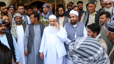 Muhammad Ismail Khan, klädd i helvitt, omringad av sina anhängare vid hans hus i Herat.