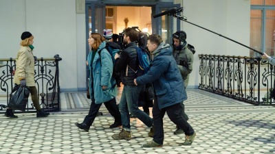 Skådespelaren Seidi Haarla går på en tågstation och en kameragrupp följer henne. 
