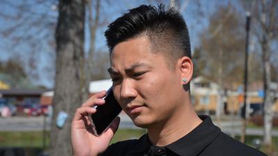 Ung man med vietnamesiskt ursprung i telefon