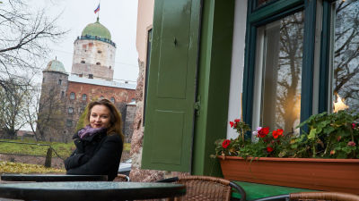 Anna Kortelainen viipurilaisessa kahvilassa 2016. Taustalla Viipurin linna.