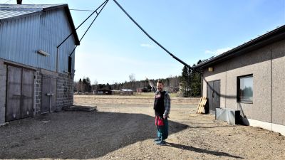 en konstnär pekar på en sladd som hänger från ett hus