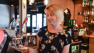 Nora Heikkilä fyller på öl i ett stop på pubben för Hotelli Zilton.