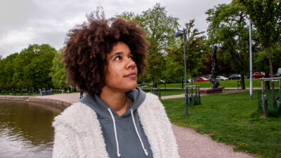 Akunna Onwen står vid Tokoi stranden och tittar mot horisonten.