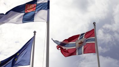 Finska flaggan, norska flaggan och EU:s flagga vaijar i vinden.