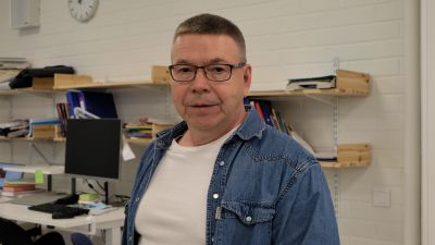 en medelåldersman i jeansjacka och grått hår
