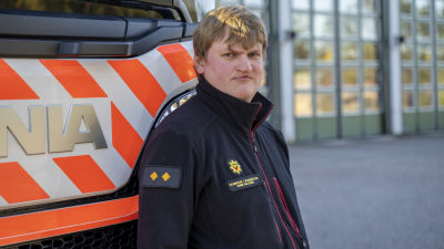 Brandmästare Henrik Hellström står vid en brandbil.
