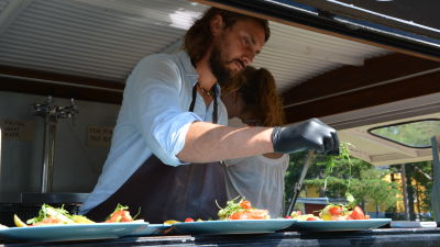 Patrik Laine snyggar till en matportion i servereingsluckan till en svart foodtruck.