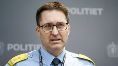 Man i polisuniform talar under en presskonferens.