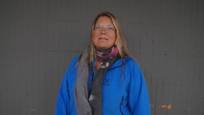 Erika Andersson tittar in i kameran. I bakgrunden en grå vägg.