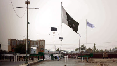 Den här bilden på gränsövergången Spin Boldak är tagen från den pakistanska sidan om gränsen. I bakgrunden, på den afghanska sidan, syns talibanernas vita flagga. Flaggan pryds av den muslimska trosbekännelsen.