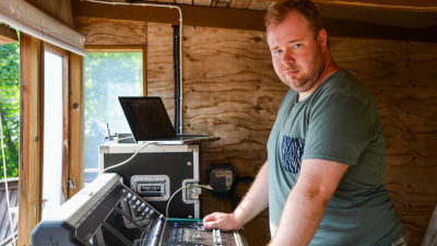 En man vid ett mixerbord och en bärbar dator.