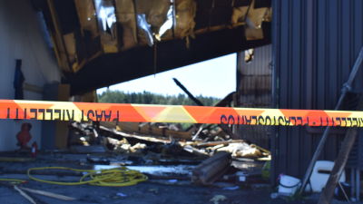 Säkerhetsband avgränsar ruiner efter brand.