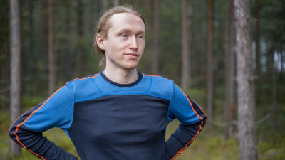 Man i löptröja i skog