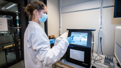 Tutkija Sari Hannula tutkii sekvensaattorin näyttöä FIMMin laboratoriossa.