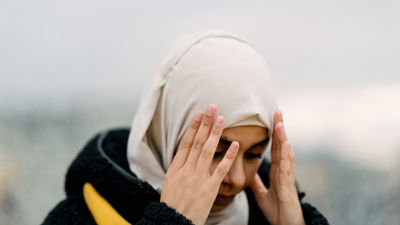 Kvinna i svart rock och vit hijab. En hijab är ett tygstycke som täcker bärarens hår och hals.