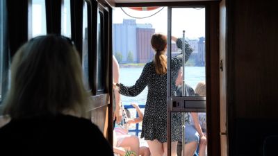 En ung kvinna står i en båt och tittar ut över Vasa stad.