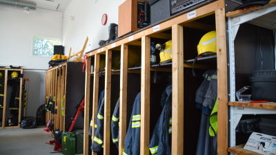 Brandmansutstyrsel hänger på rad i knaggar.