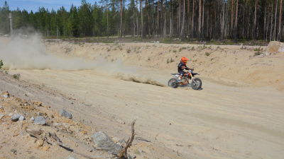 En motocrossförare kör på en sandbana.