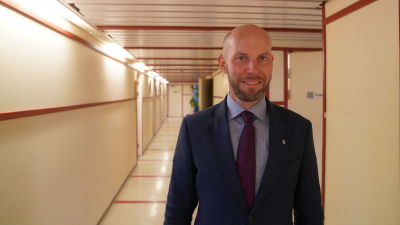 Claes Nordmark ser in i kameran. I bakgrunden en korridor.