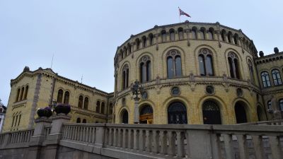 Parlamenttirakennus. Katolla liehuu Norjan lippu.