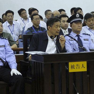 Bo Xilai istuu poliisien välissä.