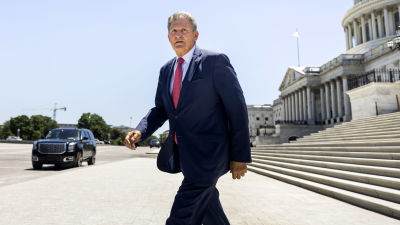 Joe Manchin lämnar Capitolium i soligt väder.