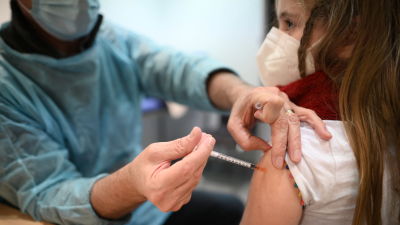 Ett barn får en spruta med coronavaccinet i armen.