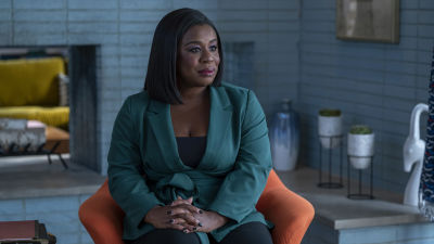 Skådespelaren Uzo Aduba sitter i en orange fåtolj i ett lyxigt inrett rum.