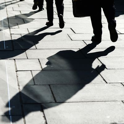 jalankulkijoiden varjoja kadulla