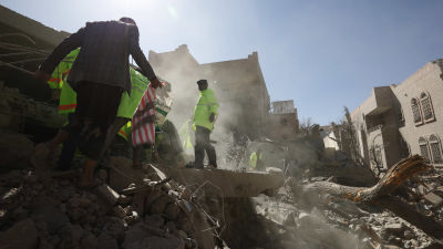 Räddningsarbetare letar efter överlevande i byggnader som förstördes i en saudiaabisk flygattack mot ett bostadsområde i Jemens huvudstaden Sanaa.
