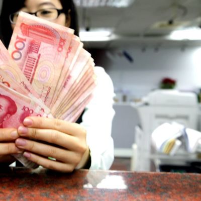 Taiwanilainen postivirkailija käsittelee kiinalaisia juaneita.