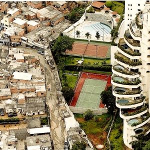 Eriarvoisuus Brasiliassa. Kuvassa köyhä Paraisopolisin favela ja aidan takana rikas naapurustoSao Paulossa ja aidan takana luksuskerrostalo uima-altaineen ja tenniskenttineen.