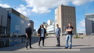 Four Punch Letdown-yhtyeen jäsenet promokuvassa. Jäsenet seisovat tehdasalueella aurinkoisena päivänä. // Kuva: Kellari / Four Punch Letdown