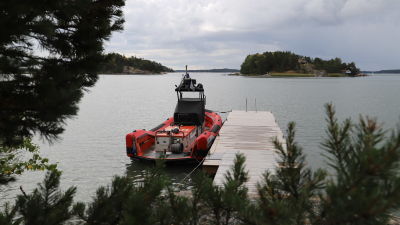 En röd sjöräddningsbåt som är förtöjd vid en brygga.