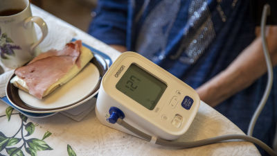 Bild på ett matbord med en smörgås och en blodtrycksmätare. 