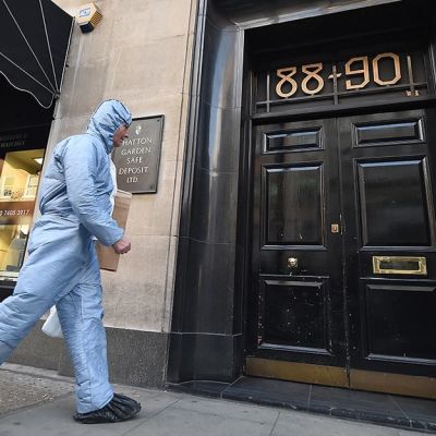Erikoistutkija sinisessä asussaan saapumassa Hatton Garden -turvasäilytyspaikkaan Lontoossa 7. huhtikuuta.