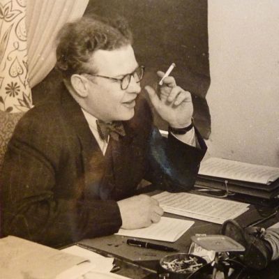 Vanha valokuva, jossa aikuinen mies katsoo pöydän yli pientä poikaa.
