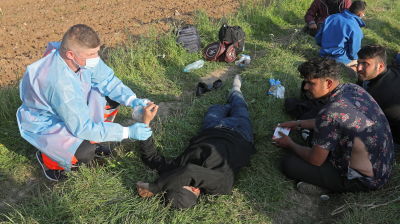 Ambulanspersonal behandlar afghanska migranter i skogen vid gränsen mellan Belarus och Polen.